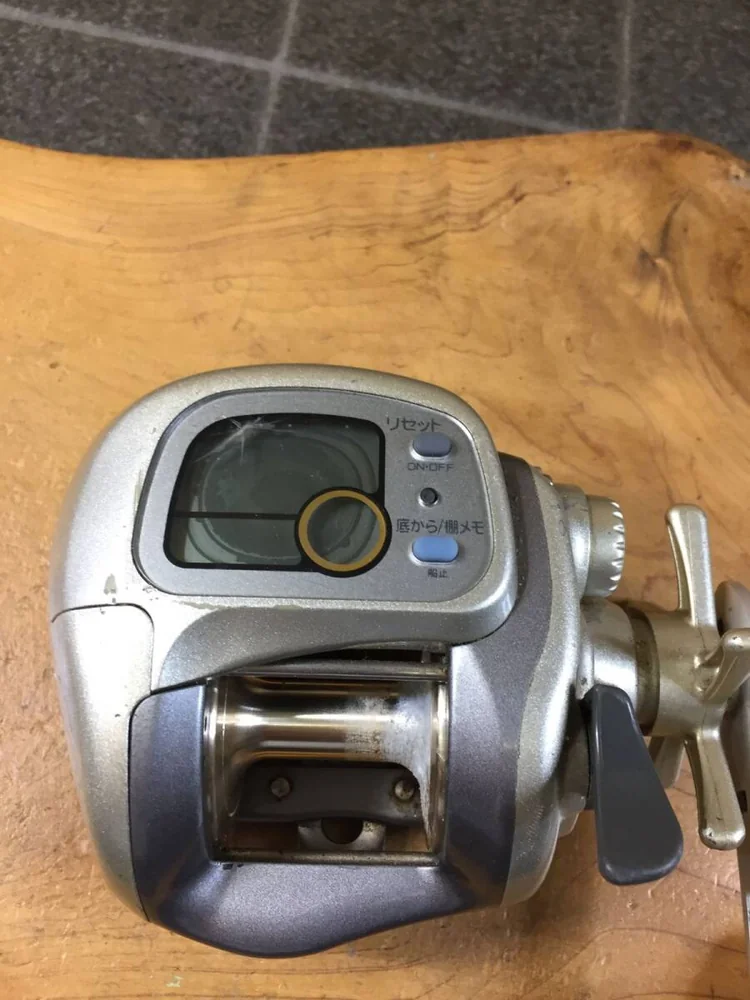 卷线器摇柄与本体细节,可见二手使用产生的污渍、划痕与锈迹
