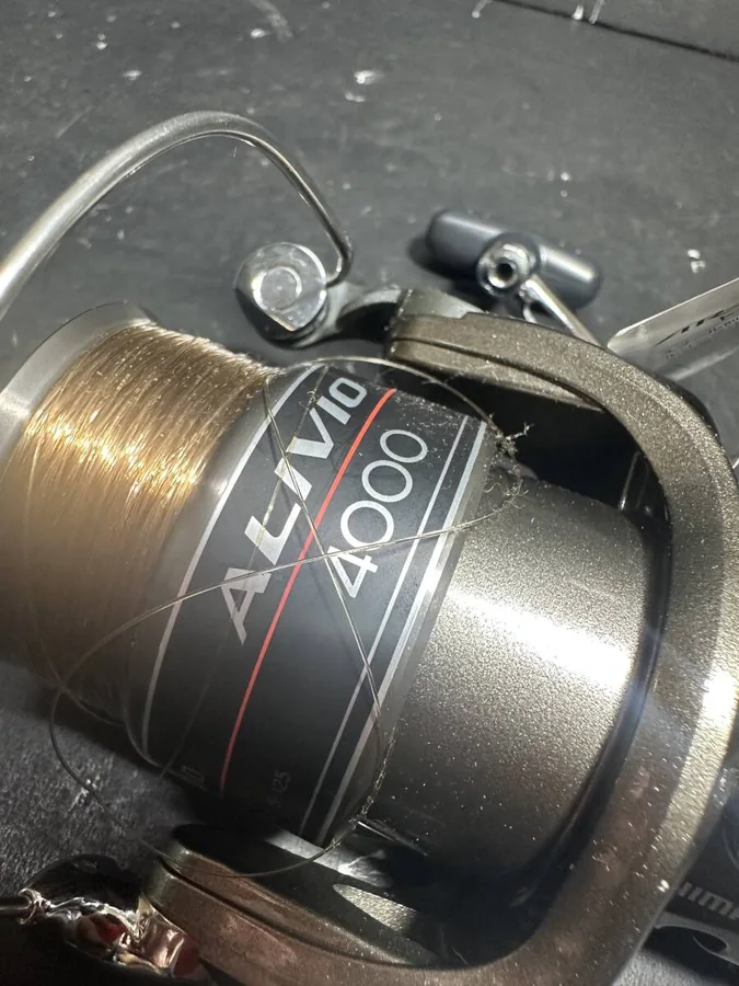SHIMANO ALIVIO 4000 纺车轮局部细节，可见长期保管留下的擦痕与细小划痕